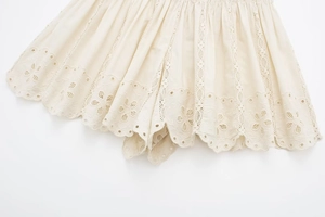 Detailed view of cream lace shorts with eyelet embroidery and scallop edges