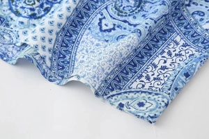 Macro detail of blue paisley print on lightweight summer woven fabric with fine texture