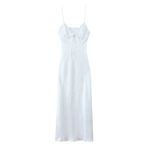 Close-up detail of white midi dress featuring ruffled neckline and delicate bow tie