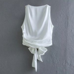 Elegant white sleeveless satin top with round neck, side ruching and a large waist bow