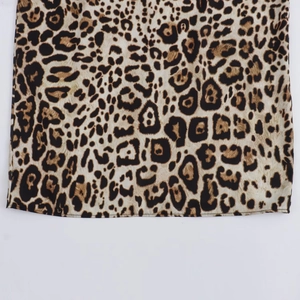 Détail du tissu à imprimé léopard avec coutures soignées sur l'ensemble jupe et chemise