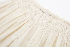 Detailed view of women's summer set featuring smocked fabric and delicate lace embroidery