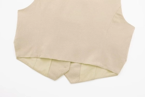 Detailed close-up of light beige linen vest hem showing fabric texture and neat stitching