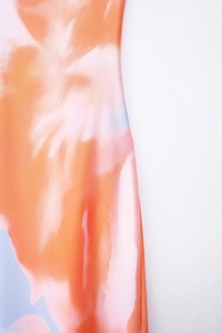 Vue macro détaillée de la texture du tissu tie-dye orange et rose vif de la robe