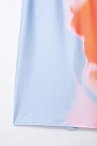 Détail du tissu tie-dye bleu montrant les coutures précises de l'ourlet de la robe