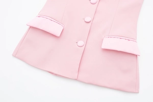 Gros plan de la veste rose en satin avec boutons recouverts et poches à rabat