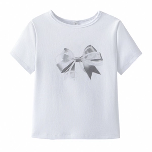 Détail d'un t-shirt blanc à col rond avec un motif de nœud papillon argenté brillant