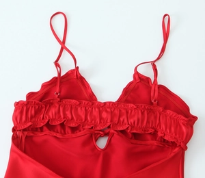 Detail of red satin dress with adjustable straps and tiered ruffle back design