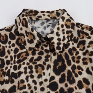 Détail du col de chemise imprimé léopard avec tissu tissé fin et bouton noir