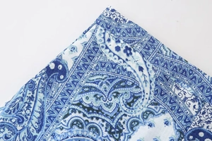 Close-up detail of blue paisley print pattern on the fabric of a 2024 summer set