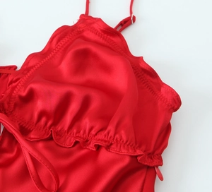 Detail of red satin dress featuring ruffled neckline and adjustable thin straps