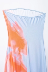 Détail du tissu extensible tie-dye bleu et orange avec texture fine sur une robe bustier