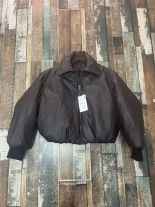 Detail of dark brown faux leather puffer jacket with metallic zipper and M size price tag