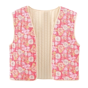 Vue détaillée du motif floral rose et des surpiqûres verticales sur le gilet matelassé