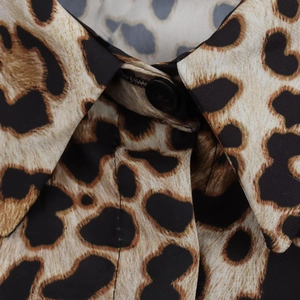 Détail du col de chemise imprimé léopard avec bouton noir et texture de tissu tissé fin