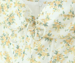 Dettaglio di un abito estivo a fiori con stecche stile corsetto e scollo a volant