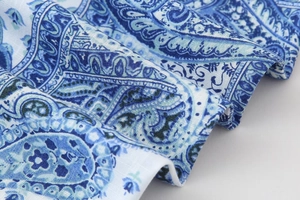Close-up detail of blue paisley print fabric showing intricate textile patterns and texture