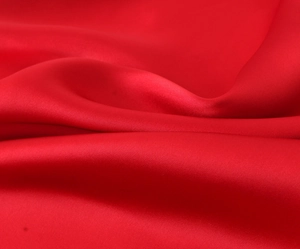 Detailed close-up showing the smooth texture and elegant sheen of red satin midi dress fabric