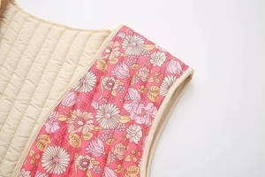 Détail du gilet matelassé réversible avec coutures parallèles et motif fleuri