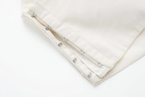 Détail du haut bouffant blanc avec système de fermeture réglable à crochets métalliques