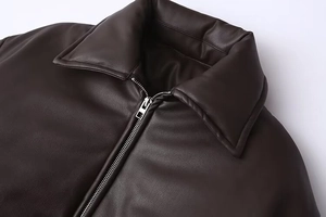 Detailed view of dark brown faux leather jacket with high-quality zipper and collar