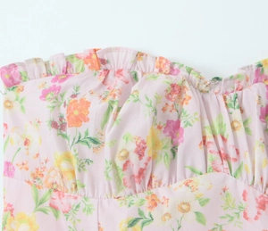Détail du col à volants et plis sur une robe d'été en coton à imprimé floral rose