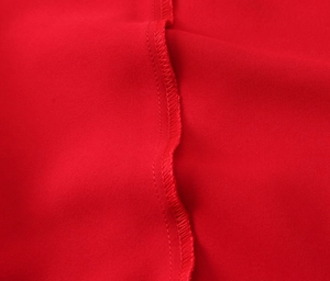 Detail view showing precision overlock stitching and high-quality red satin fabric texture
