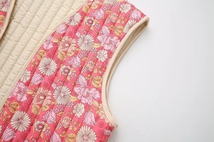 Détail du gilet en coton matelassé à fleurs avec imprimé marguerites et surpiqûres