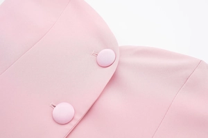 Détail du tissu satiné rose clair avec boutons recouverts assortis et coutures fines