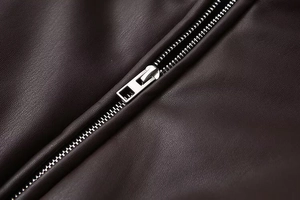 Close-up of silver metal zipper detail on high-quality dark faux leather jacket