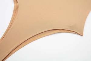 Macro detail of nude bodysuit showing high-quality stitching and seamless knit fabric