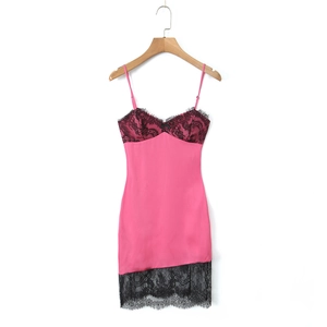 Détail d'une robe en satin rose avec bordures en dentelle noire et petit nœud décoratif