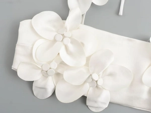 Detail of white satin camisole featuring three-dimensional floral appliqué with bead centers