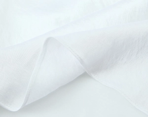 Close-up detail of white satin midi dress fabric texture and fine hemline stitching