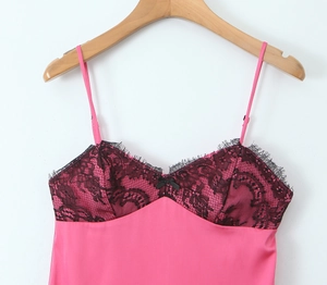 Détail de la robe en satin rose avec dentelle noire et petit nœud sur le décolleté