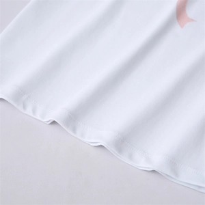 Détail de l'ourlet du T-shirt blanc avec imprimé ruban rose et double piqûre soignée