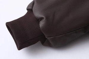 Detail of dark brown faux leather jacket with windproof ribbed knit cuffs and stitching