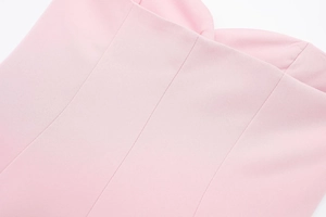Détail de robe satinée rose clair avec décolleté en cœur et coutures verticales précises