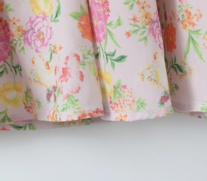 Détail macro de l'ourlet de robe en coton à fleurs roses avec couture et bords roulés fins
