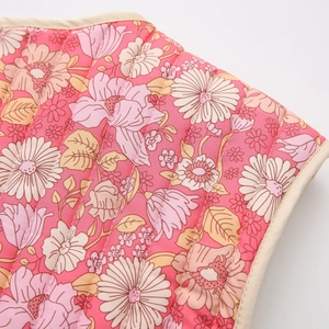 Gros plan sur un tissu en coton matelassé à fleurs avec surpiqûres et bordure crème