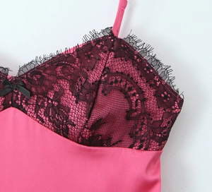 Détail de robe en satin rose avec dentelle noire et un petit nœud élégant sur le devant