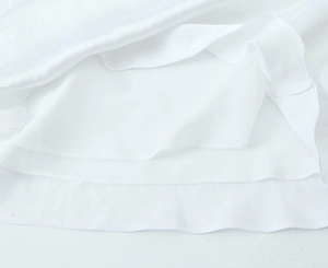 Detailed close-up showing the double-layered hem and fine stitching of the white midi dress