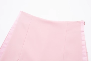 Détail de jupe rose clair taille haute avec fermeture éclair invisible et tissu texturé