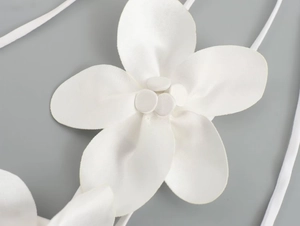 Macro view of white satin 3D floral decoration with delicate elastic strap detail