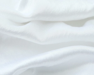 Macro shot of white satin fabric showing soft natural folds and detailed fiber texture