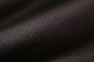 Macro shot of dark brown faux leather material showing premium lychee grain texture