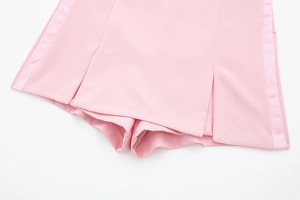 Détail de la jupe-short de sport rose avec rayures latérales et fente frontale