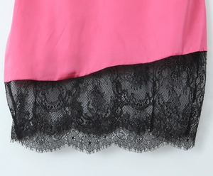 Vue détaillée de l'ourlet rose avec dentelle florale noire délicate à cils