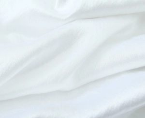 Close-up of elegant white satin fabric showing smooth texture and soft draped layers