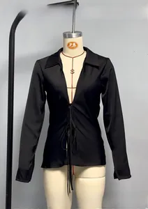 Detail of black silk satin shirt featuring adjustable bow tie neckline and V-neck collar